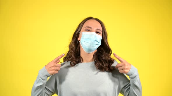 Attractive Curly Young Wearing Face Mask Isolated on Yellow