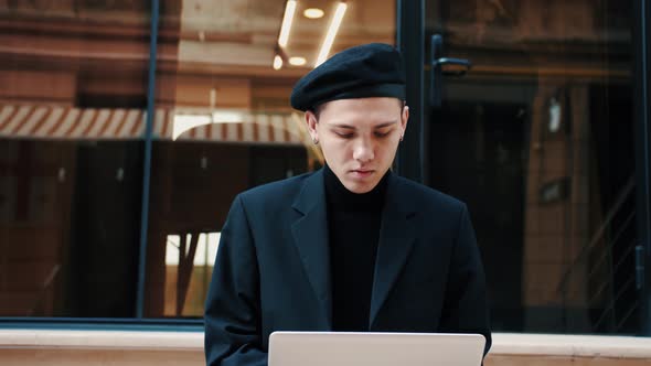 Caucasian Man Sitting on Stairs and Working Outdoors. Businessman Freelance Work. Businessman