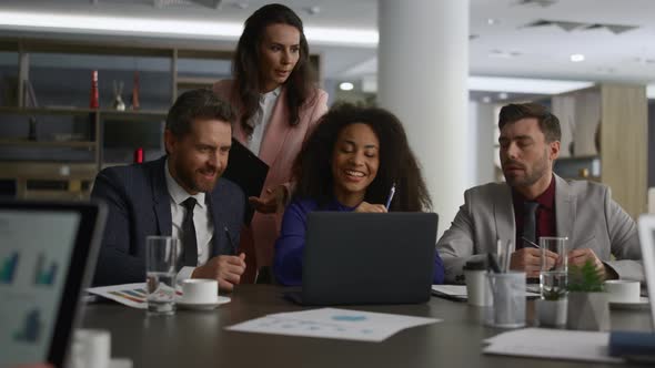 Business Team Sharing Ideas Researching Laptop Computer in Office Building