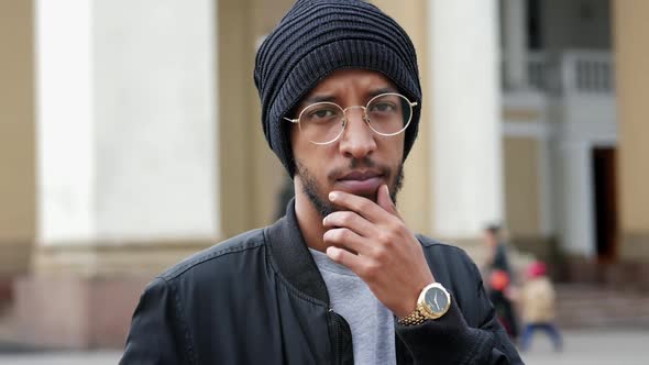 Street Portrait of a Serious Man with Glasses and a Hat Looking at the Camera in Slow Motion