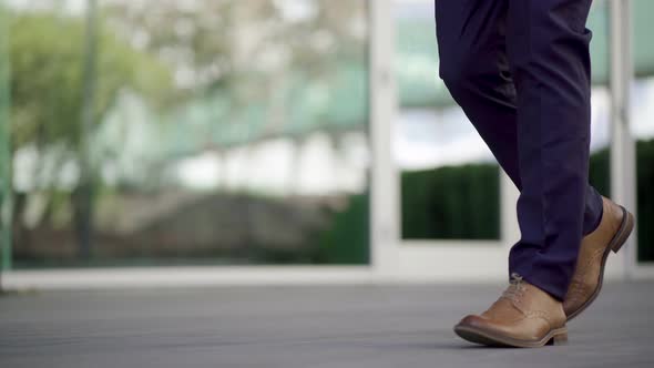 Low Section of Businessman Walking on Street