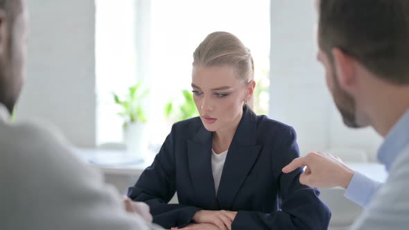 Angry Male Business People Scolding Young Businesswoman