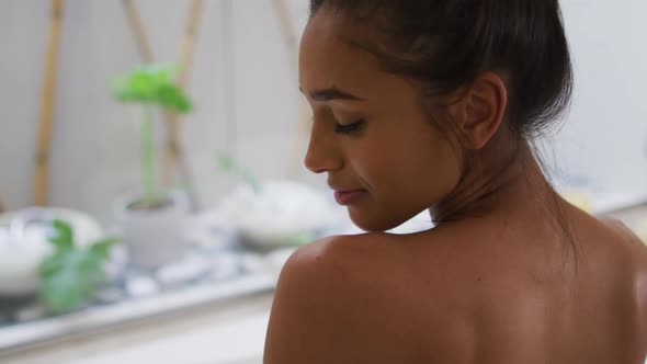 Mixed race woman lying in a bathtub at home