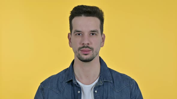 Portrait of Young Man Looking at the Camera, Yellow Background