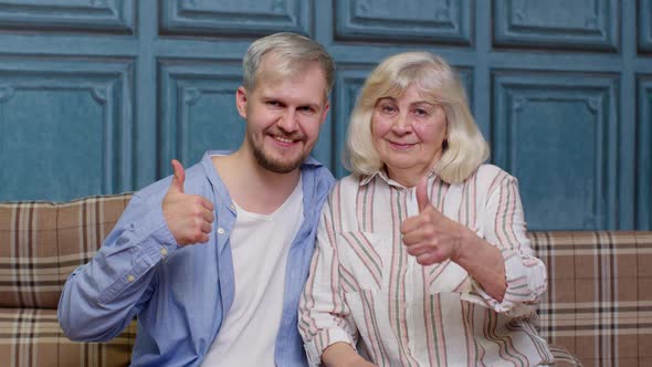 Family of Senior Grayhaired Mother and Handsome Adult Son or Grandson Showing Thumbs Up Gesture