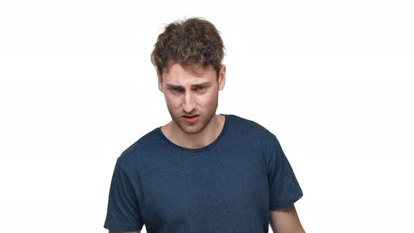 Portrait of Impudent Guy in Tshirt Being Aggressive and Swearing with Irritation Isolated Over White