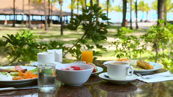 Breakfast in Outdoors Restaurant at Luxury Exotic Resort with Sea and Palm Trees