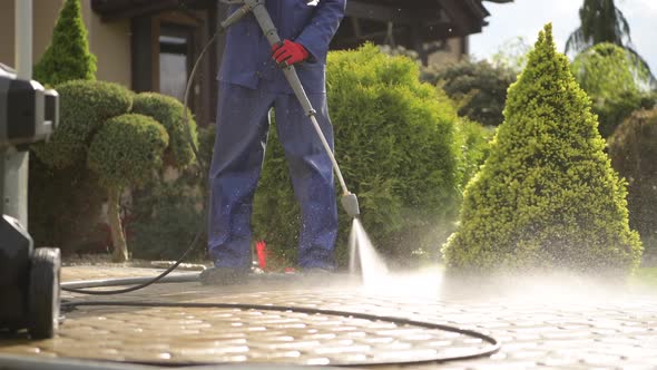 Men Using Pressure Washer For Driveway Cleaning.