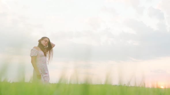 Girl in a White Dress in a Wheat Field at Sunset