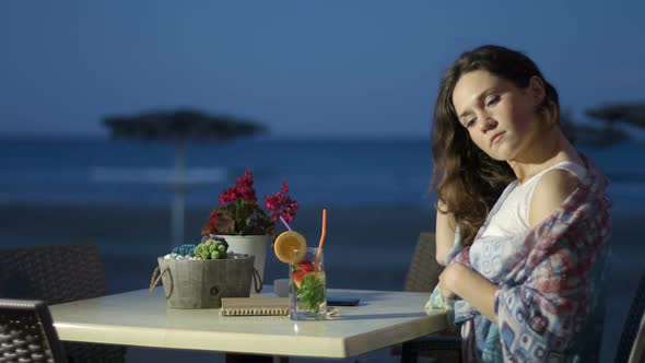 Thoughtful Pretty Female Enjoying Cocktail at Seaside Restaurant, Romantic Mood