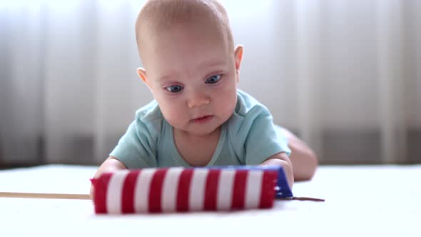 Little Baby Infant Lying on the Floor Looking at American Flag