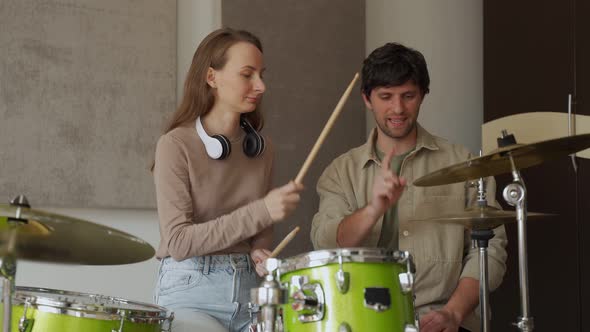 Young Woman Takes Drum Classes From Male Teacher in Studio