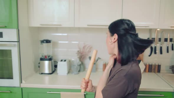 Young Woman in Brown Tshirt Singing and Dancing While Baking at Home Kitchen