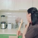 Young Woman in Brown Tshirt Singing and Dancing While Baking at Home Kitchen - VideoHive Item for Sale