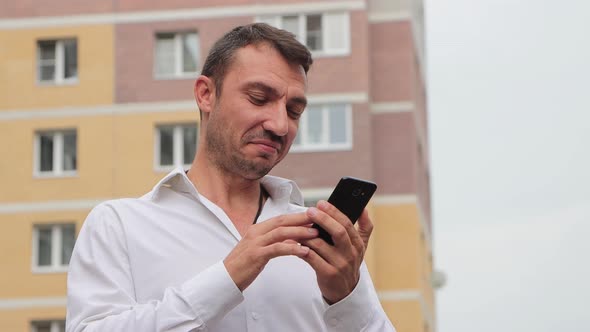 Closeup of a Happy Businessman Laughing and Dialing the Number