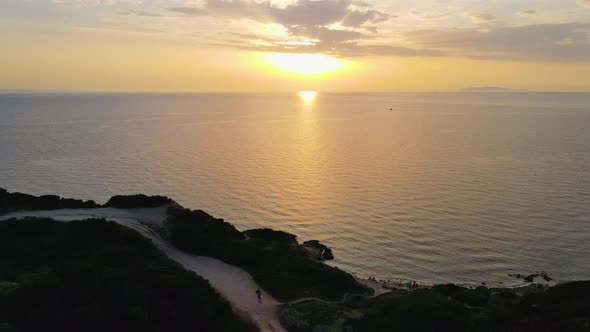 Magical tracking shot aerial drone view of coastline at sunset in Sardinia, Italy