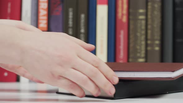 Hands picking up books