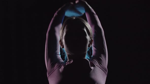 Young Female Gymnast on Training  Warming Up  Neon Contrast Lighting