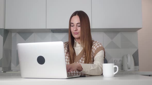 The Girl in Disbelief From What She Saw or Read Closes the Laptop While Sitting in the Kitchen