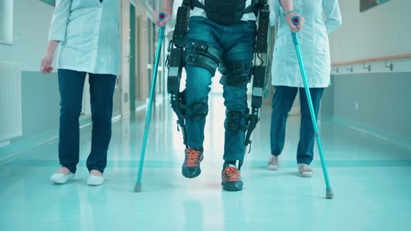 Hospital Hall with Medical Workers and a Patient in Exoskeleton