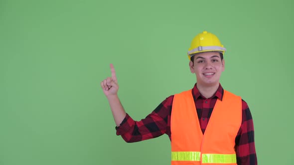 Happy Young Multi Ethnic Man Construction Worker Talking While Pointing Up