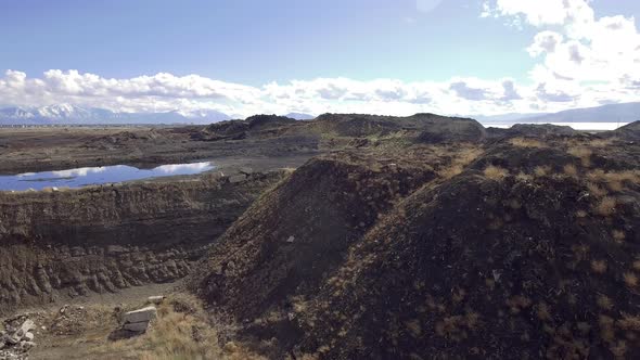 An aerial drone shot flying past the catch pond and slag heap from the former Geneva Steel mill.