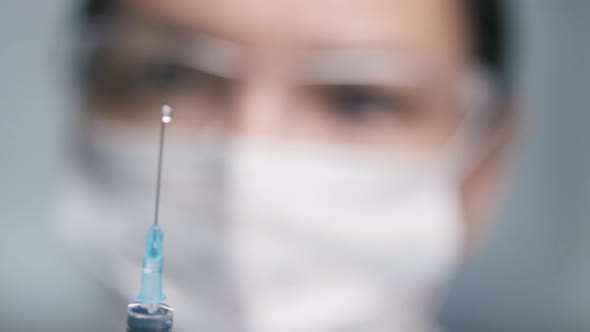 Rack Focus of Female Doctor Squirting Medicine from Syringe