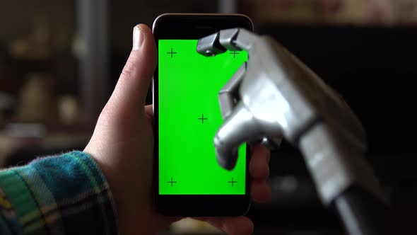 Cyborg Uses the Phone. Gray Mechanical Hand Swipe Down on Smartphone with Green Screen. Chroma Key.