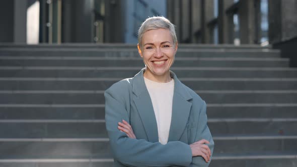 Woman Standing on Street with Crossed Arms and Smiling