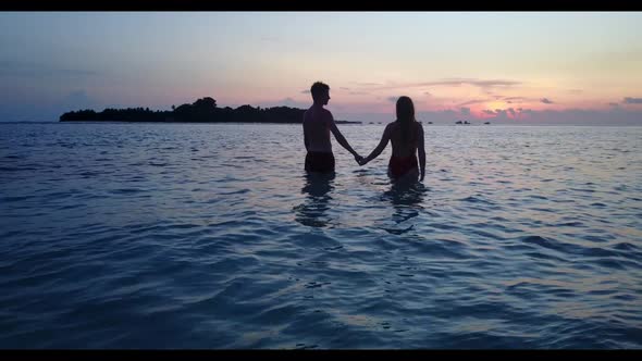 Teenage lovers tan on marine sea view beach break by blue sea and white sandy background of the Mald