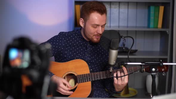 Portrait of Cheerful Guitarist Singer Male Playing Acoustic Guitar and Singing Song Recording Video