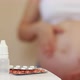 Medical drugs and a pregnant girl rubbing her belly on the background. - VideoHive Item for Sale