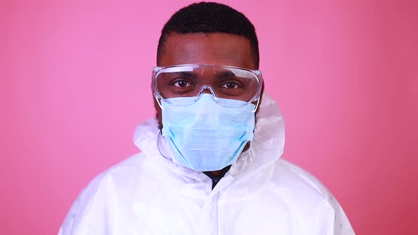 African American Man Scientist in PPE Suite Uniform Showing Medicine Liquid Vaccine Vial Bottle