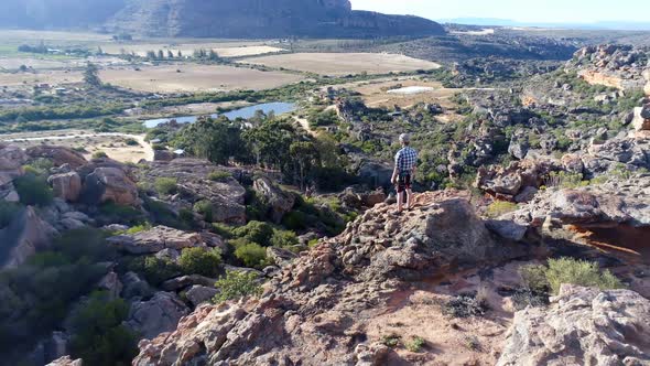 Male rock climber standing over a rocky mountain 4k