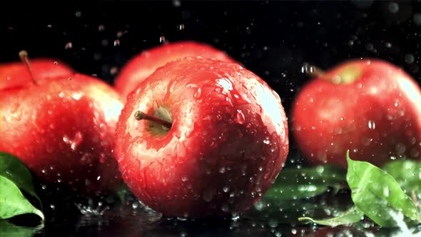 Drops of Water with Splashes Fall on the Red Apples