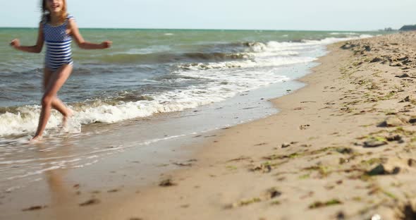 Happy, joyful little girl run on the beach Very fast , sea family vacation