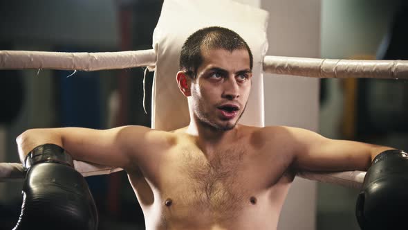 Man Boxer Sitting on the Chair in the Corner of the Ring