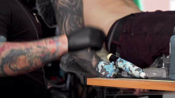 Tattoo Artist Taking Tattoo Machine, Working at His Studio