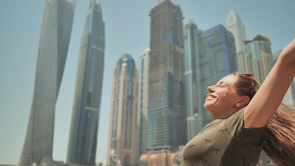 A Happy Girl is in Dubai on a Background of Skyscrapers Dubai Marina