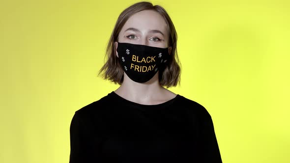 Woman in face mask with Black Friday shopping bags in hands