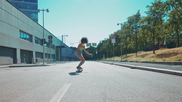 Beautiful young woman cruising around the city with her longboard.