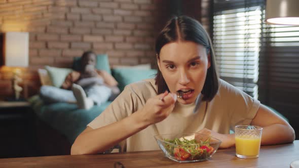 Young Woman Eating Salad and Chatting on Web Call