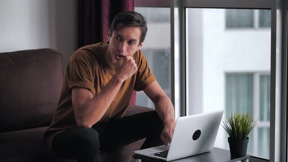 Frightened Man is Unpleasantly Surprised and Shocked By the Bad News Seen on the Laptop Screen