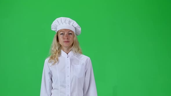 Blonde Cook Chef in White Uniform and Hat Going Against a Green Screen. Slow Motion