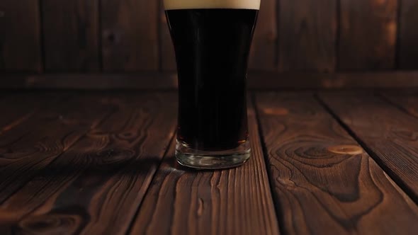 Closeup of a Glass of Chilled Dark Beer on a Wooden Surface