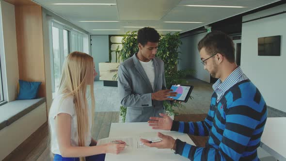 Multiracial Men and Woman Working on Report