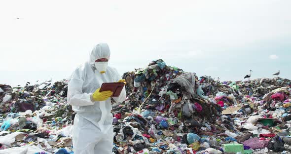 Virologist Taking Notes in His Tablet During Researching the Polluted Land