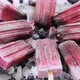 Homemade Fresh Frozen Blueberry and Blackberry Popsicles on Black Plate with Ice Sitting on Stone - VideoHive Item for Sale