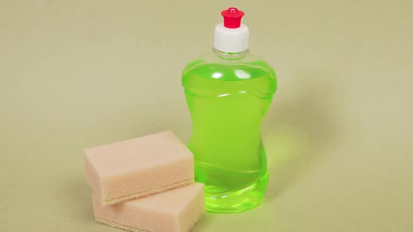 Green Dish Detergent in a Clear Bottle and Two Sponges