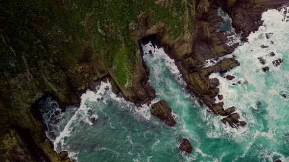 Ocean waves crash into coves eroded from huge rocky cliffs on the Big Sur coast in California